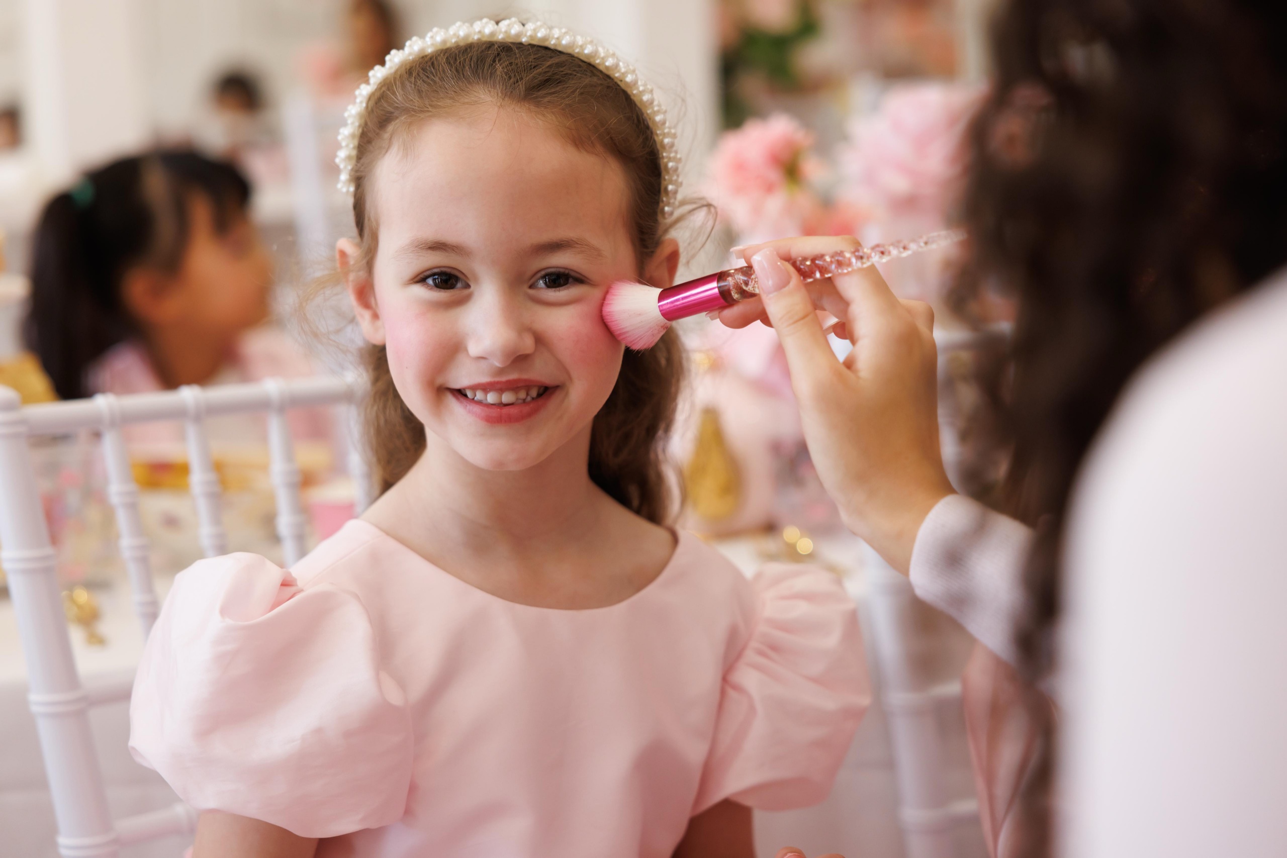 A girl having glitter make-up applied