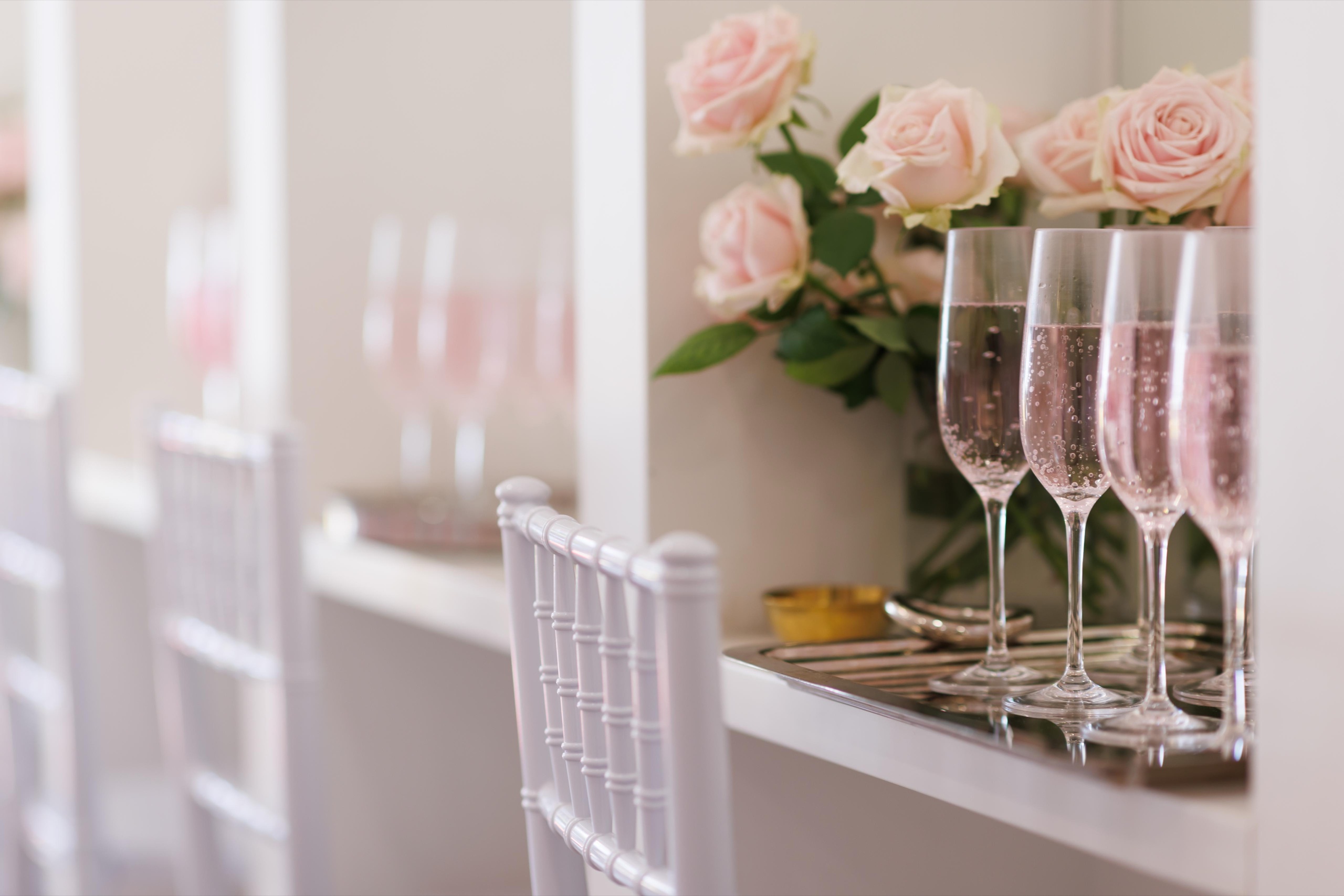 Champagne flutes beside pink roses