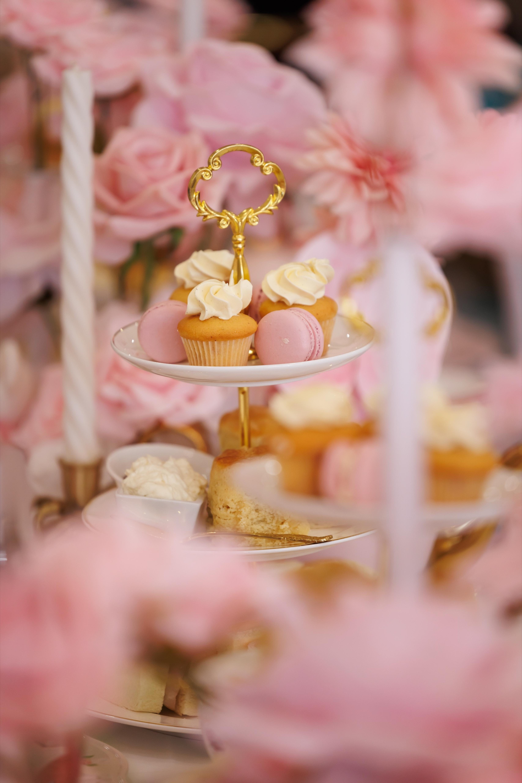 A tiered stand of cupcakes and macarons